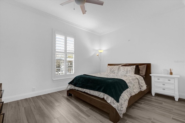 bedroom featuring ceiling fan, ornamental molding, light wood-type flooring, and baseboards