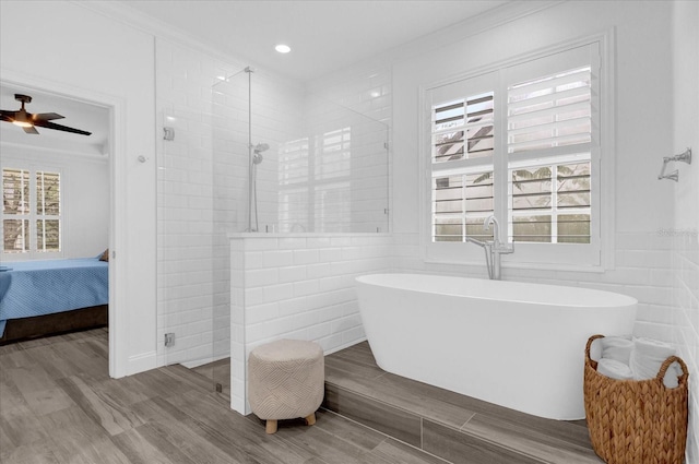 bathroom with a freestanding bath, plenty of natural light, connected bathroom, and tile walls