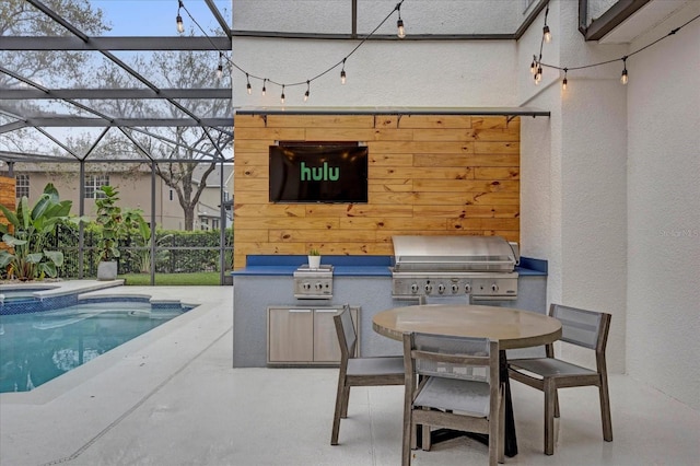 view of patio featuring glass enclosure, exterior kitchen, a grill, and an outdoor pool