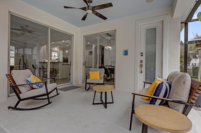 exterior space featuring plenty of natural light, ceiling fan, concrete flooring, and a textured wall