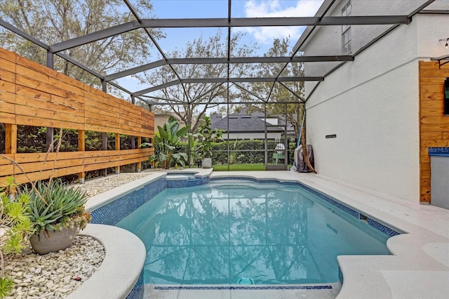 view of pool with glass enclosure and a pool with connected hot tub