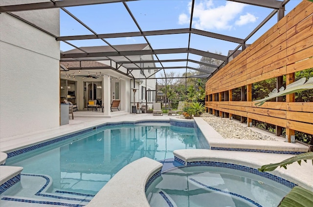 view of pool featuring a ceiling fan, a pool with connected hot tub, a lanai, and a patio