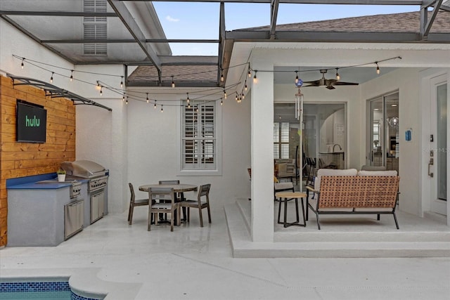 view of patio / terrace featuring exterior kitchen, outdoor dining space, glass enclosure, and a grill