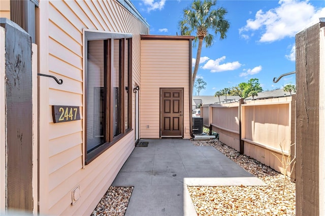 property entrance featuring central AC unit and fence