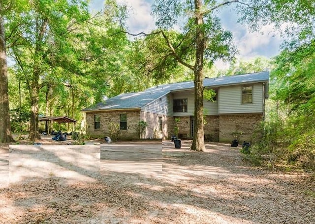 106 Thurston Pl, Crestview, FL 32536 - view of front of home featuring brick siding, dirt driveway, and a carport