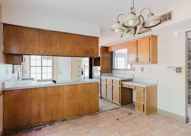 106 Thurston Pl, Crestview, FL 32536 - kitchen with a chandelier, light countertops, baseboards, a peninsula, and pendant lighting