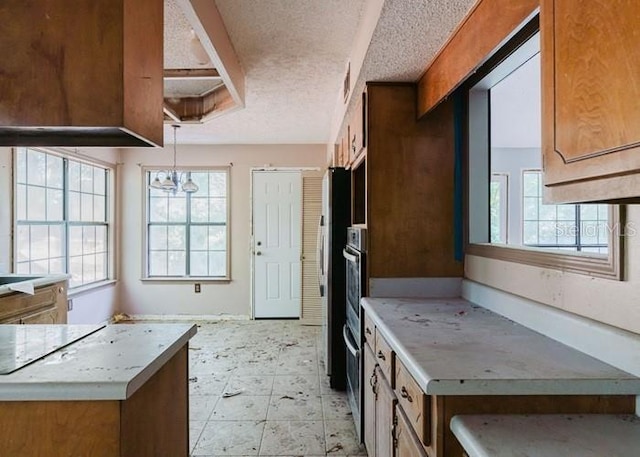 106 Thurston Pl, Crestview, FL 32536 - kitchen with a textured ceiling, light countertops, pendant lighting, oven, and brown cabinetry