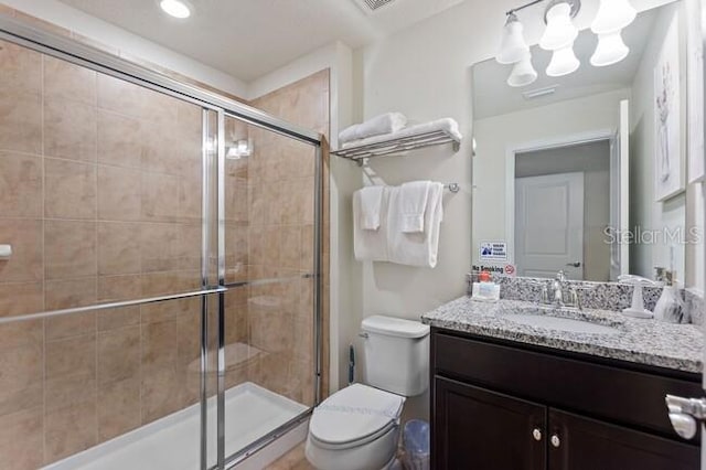 full bath featuring toilet, a shower stall, and vanity