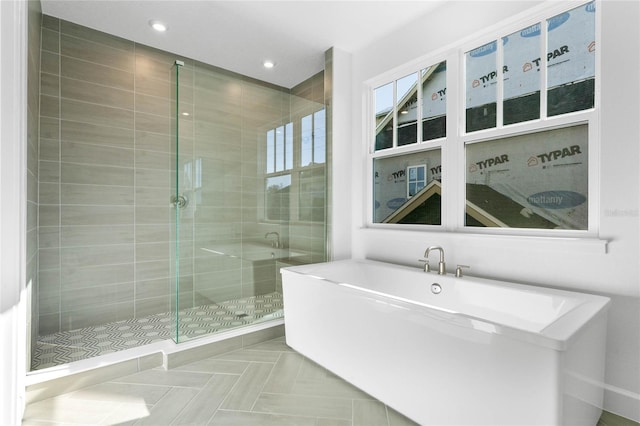 full bath featuring a freestanding tub, a shower stall, and recessed lighting