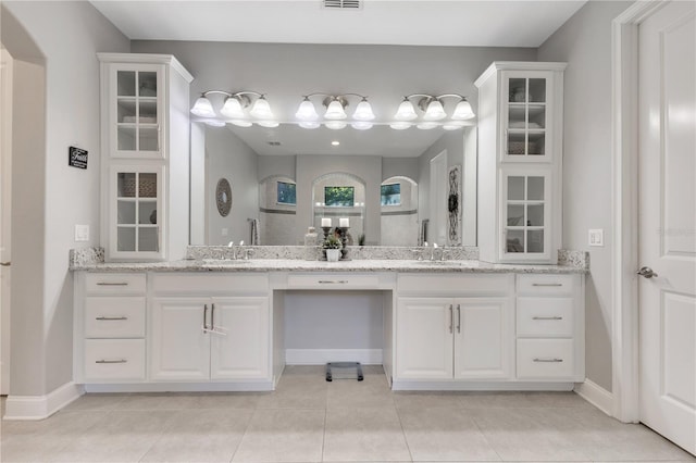 full bathroom featuring double vanity, visible vents, a sink, and tile patterned floors