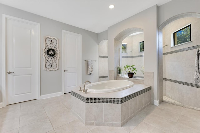 full bathroom with a walk in shower, plenty of natural light, a garden tub, and tile patterned floors