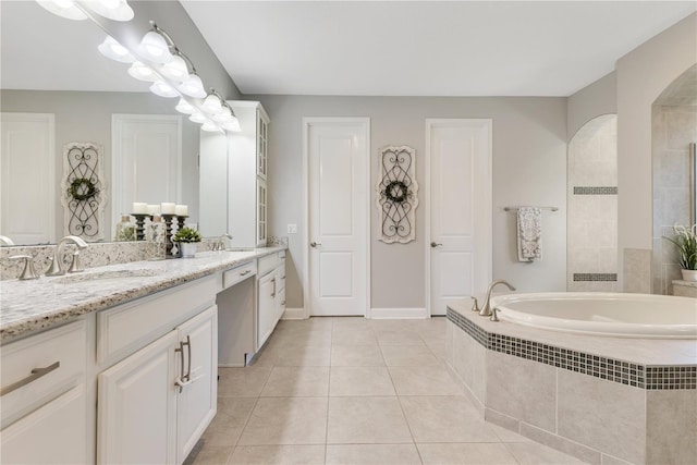 full bath featuring double vanity, a bath, tile patterned flooring, a walk in shower, and a sink