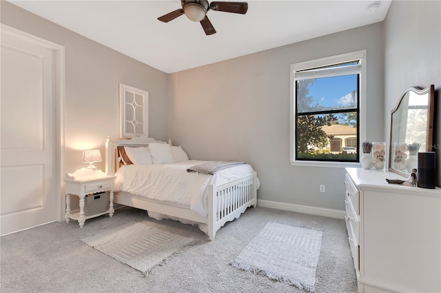 bedroom featuring a ceiling fan, light colored carpet, and baseboards