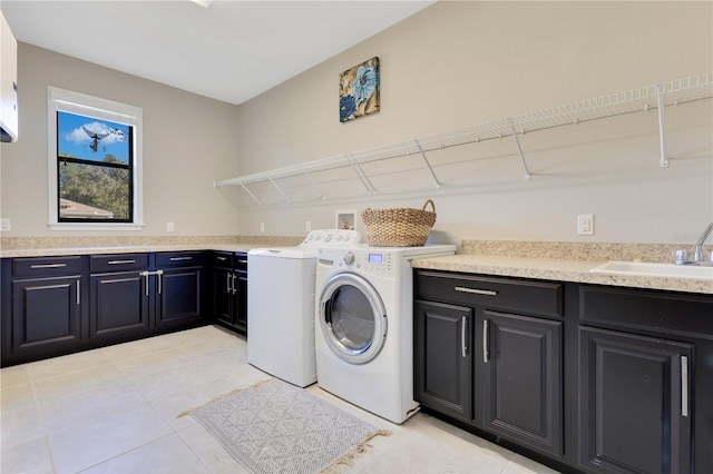 laundry area featuring a sink, washing machine and clothes dryer, and cabinet space