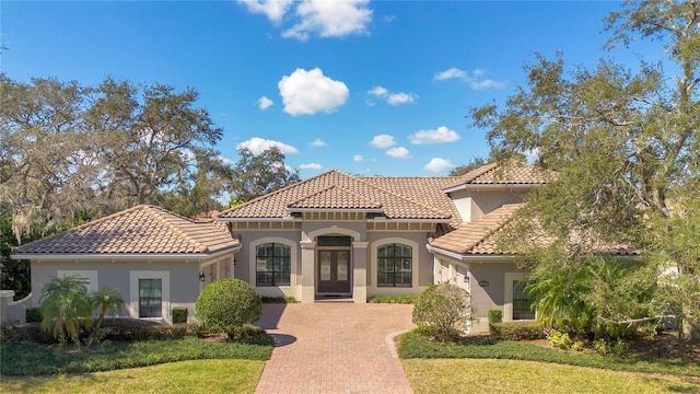 mediterranean / spanish home with a tile roof and stucco siding