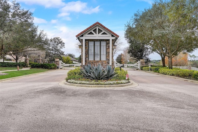 exterior space featuring a gate, curbs, and a gated entry