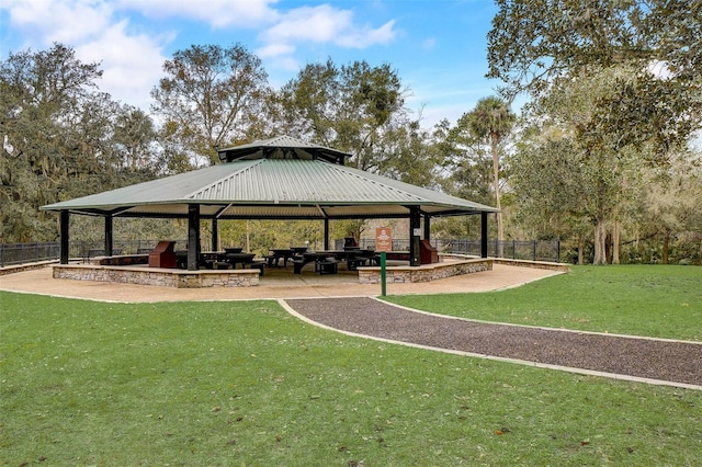 view of property's community with a gazebo, a lawn, and fence