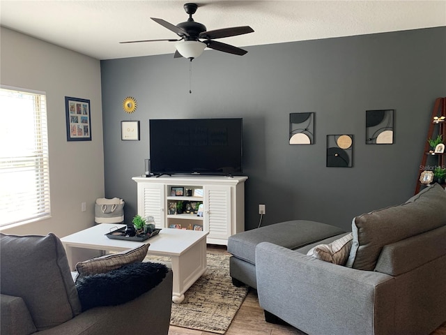 living area featuring light wood-type flooring and ceiling fan