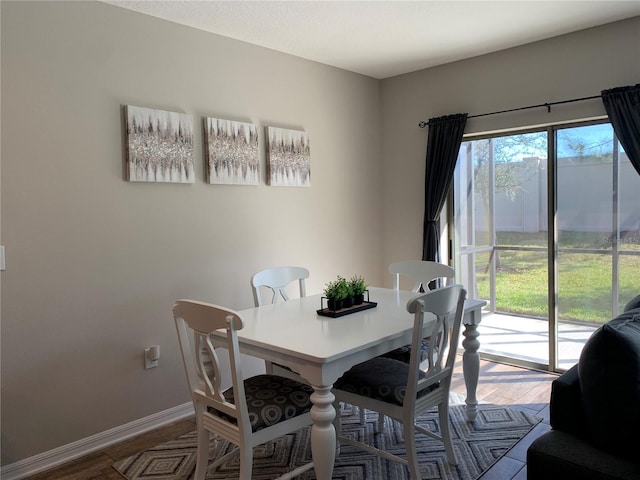 dining space featuring baseboards and wood finished floors