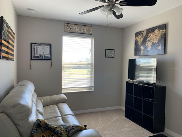 living area with carpet flooring, a ceiling fan, and baseboards