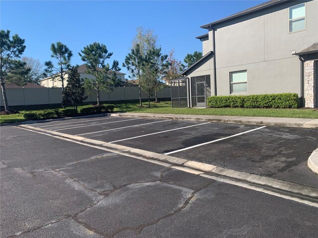 uncovered parking lot featuring fence