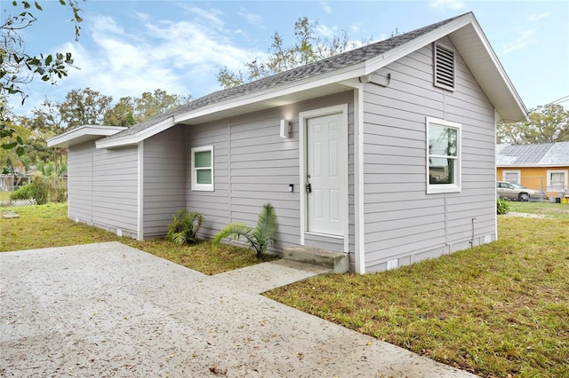 exterior space with a shingled roof, crawl space, and a lawn