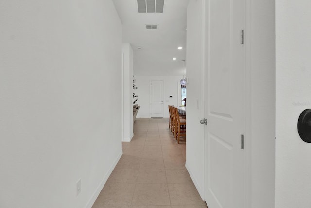 hallway with recessed lighting, visible vents, baseboards, and light tile patterned floors