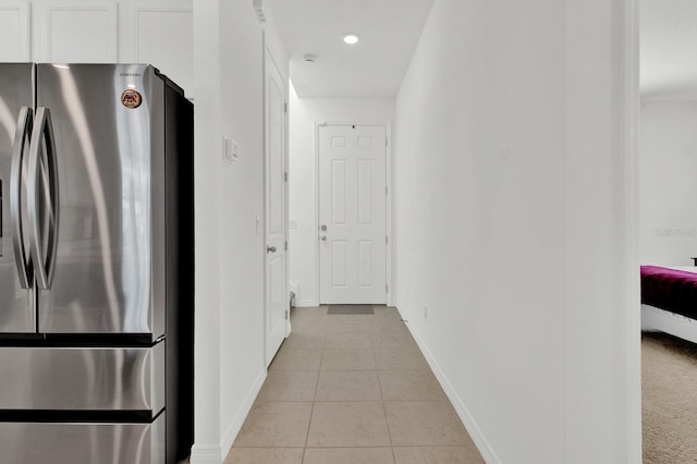 corridor with light tile patterned flooring and baseboards