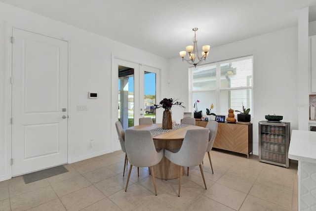 dining space with light tile patterned floors, wine cooler, a notable chandelier, and french doors