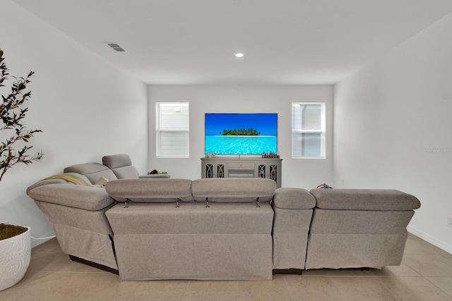 living area with a healthy amount of sunlight, visible vents, baseboards, and light tile patterned flooring