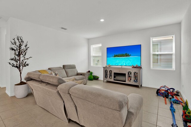 living area with light tile patterned floors, recessed lighting, visible vents, and baseboards