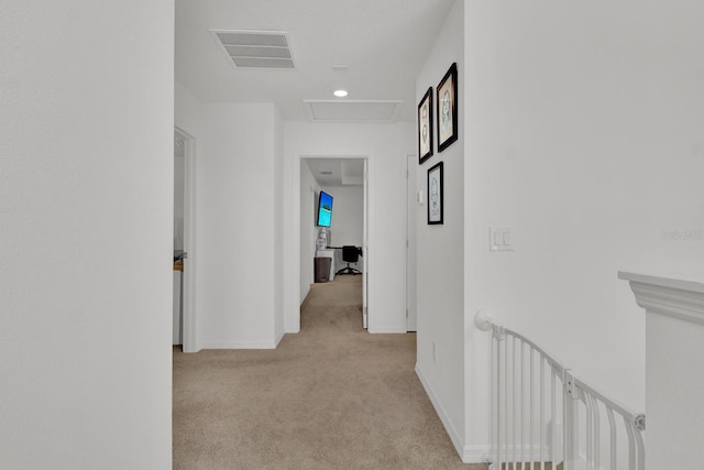 corridor with carpet, visible vents, attic access, an upstairs landing, and baseboards