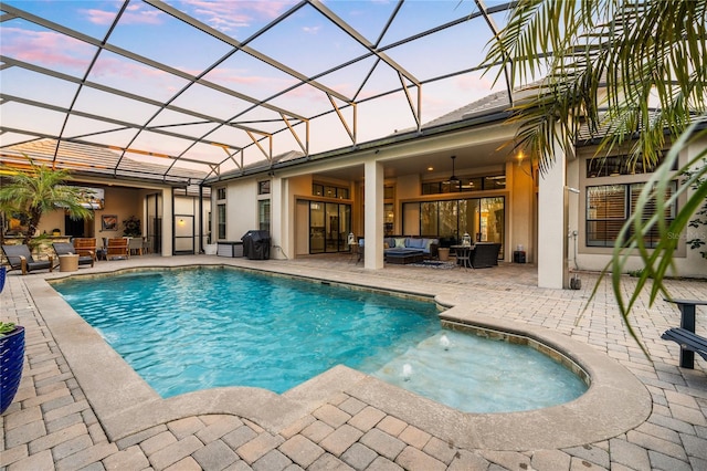 outdoor pool featuring glass enclosure, outdoor lounge area, area for grilling, a ceiling fan, and a patio area