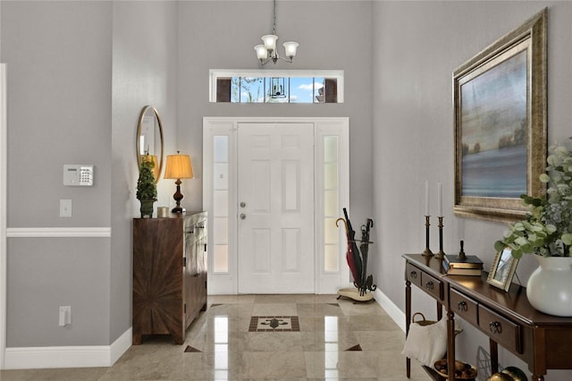 foyer entrance with a healthy amount of sunlight, baseboards, and a chandelier