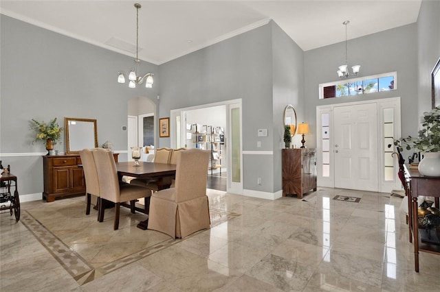 dining area with baseboards, marble finish floor, arched walkways, and a notable chandelier