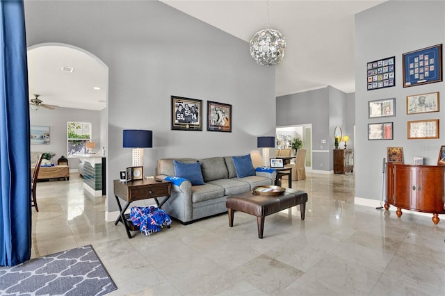 living room with arched walkways, a high ceiling, visible vents, baseboards, and marble finish floor