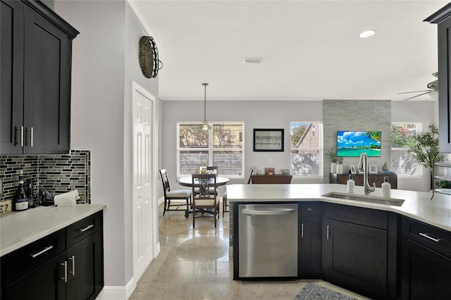 kitchen featuring a sink, visible vents, light countertops, backsplash, and dishwasher