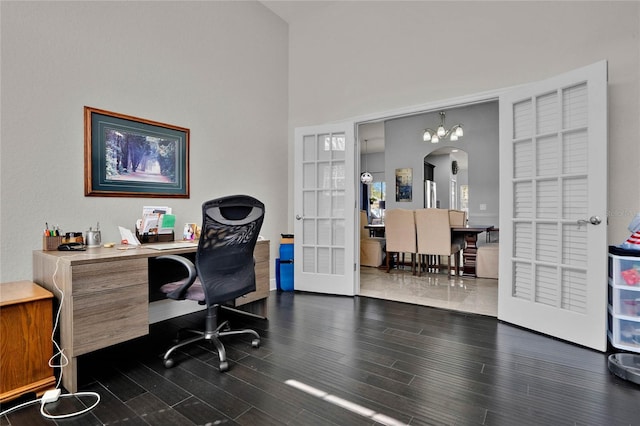 home office with a high ceiling, arched walkways, wood finished floors, and french doors