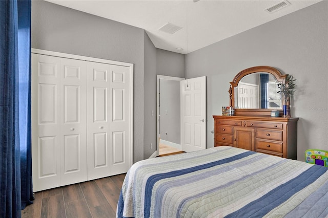 bedroom with a closet, visible vents, and wood finished floors