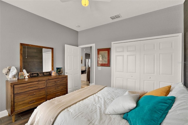 bedroom with arched walkways, visible vents, a ceiling fan, a closet, and dark wood-style floors