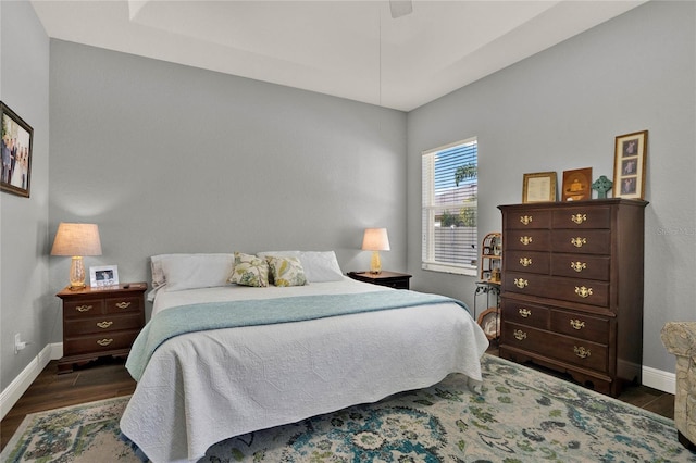 bedroom featuring wood finished floors, a ceiling fan, and baseboards