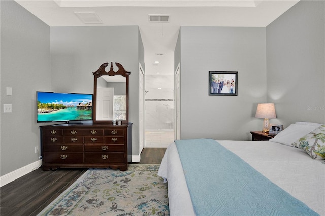 bedroom with baseboards, ensuite bathroom, visible vents, and wood tiled floor