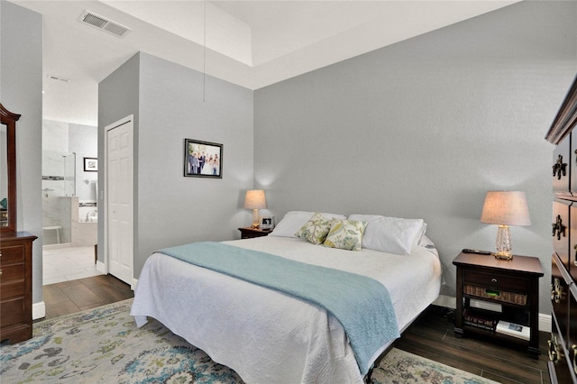 bedroom featuring visible vents, baseboards, and wood finished floors