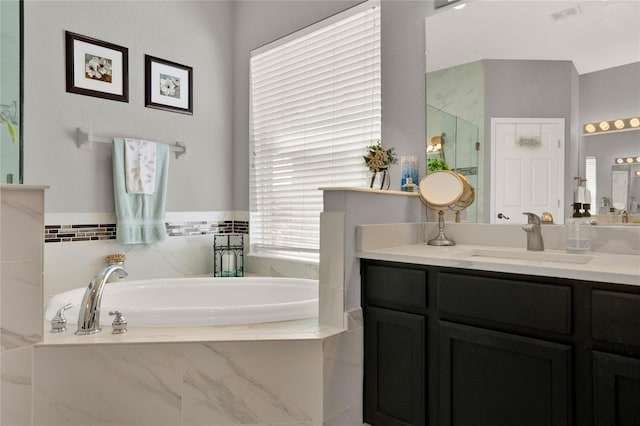 full bathroom featuring a shower, visible vents, a garden tub, and vanity