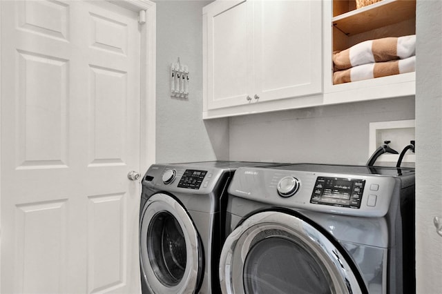 laundry room featuring separate washer and dryer and cabinet space