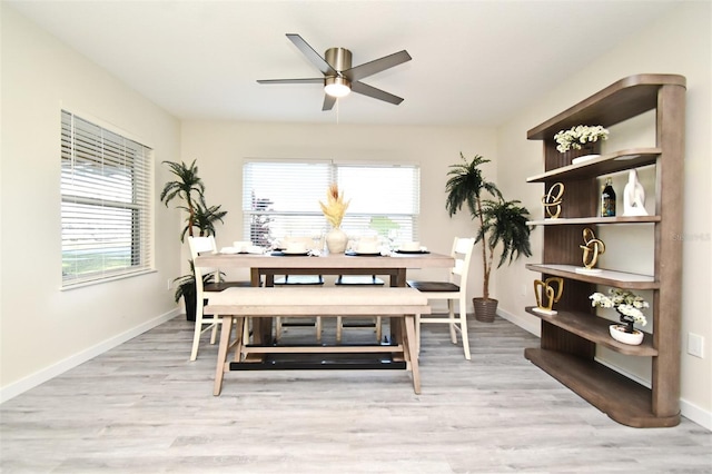 dining area with light wood-type flooring and baseboards