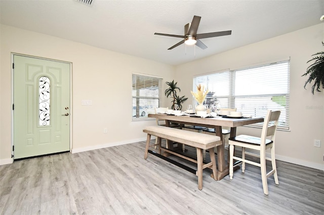 dining space with light wood finished floors, ceiling fan, and baseboards