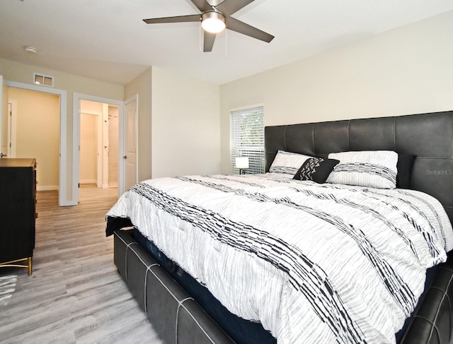 bedroom with light wood-style flooring, visible vents, and ceiling fan