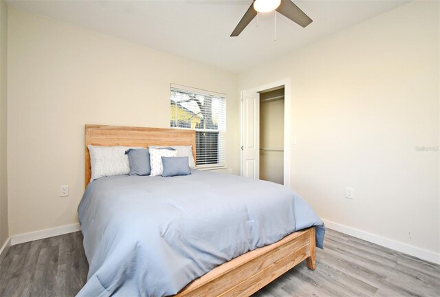 bedroom with ceiling fan, wood finished floors, and baseboards