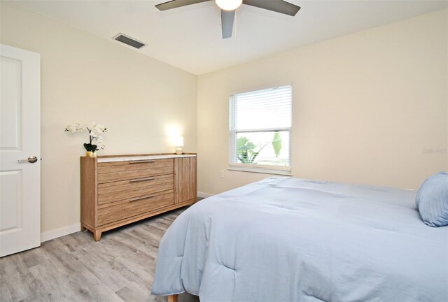 bedroom featuring visible vents, ceiling fan, light wood-style flooring, and baseboards